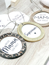 Laden Sie das Bild in den Galerie-Viewer, Beispielfoto kleiner runder Nelopii mit dem Text "Beste Mama der Welt". nelopii in 3 verschiedenen Farben Gold, Rosegold und Leo Design