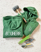 Laden Sie das Bild in den Galerie-Viewer, Dunkelgrüner Kapuzenpullover mit der Aufschrift Bauherr auf dem Rücken.